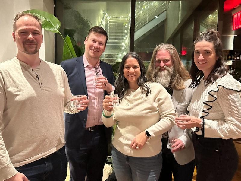 Five members of the Ample team raising glasses together